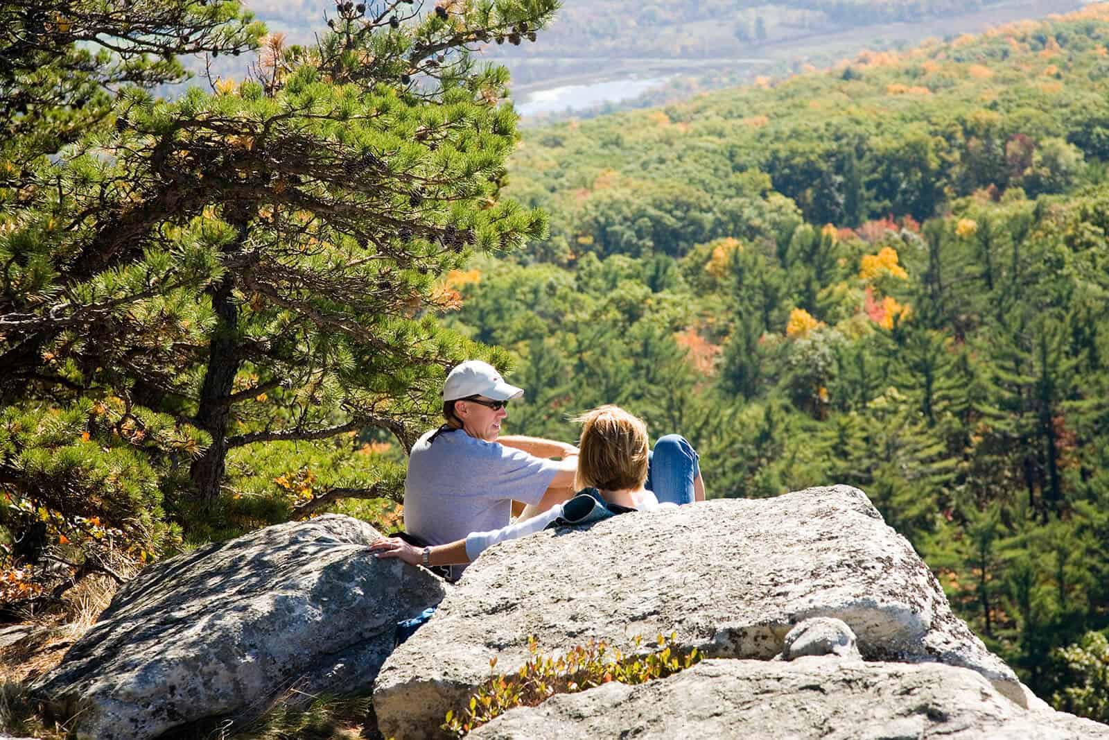 Couple sitting on rock looking at Mohonk land