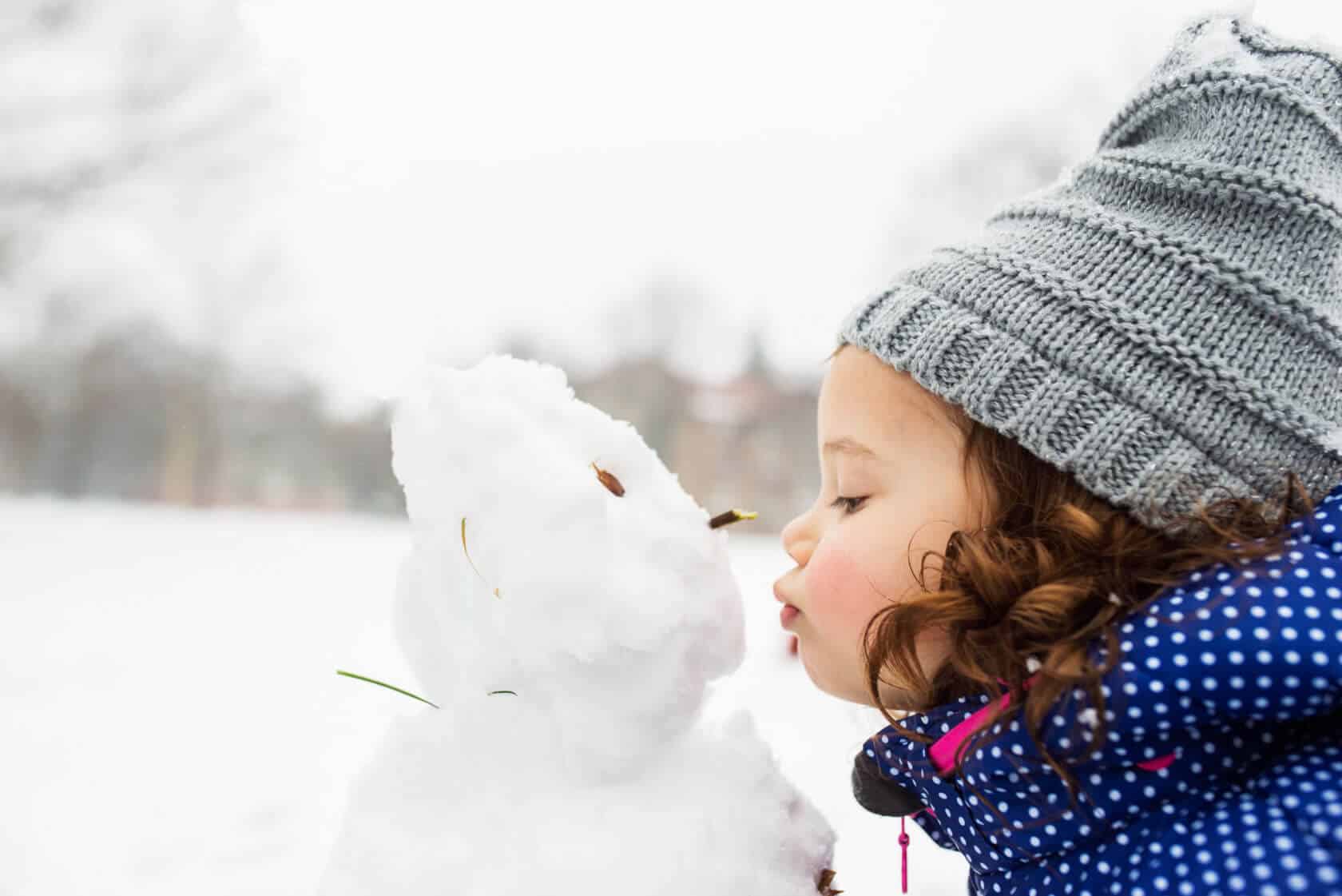 Toddler Kissing a Snowman